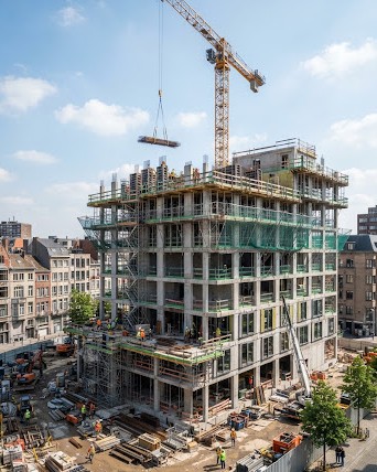 Chantier en cours de construction en Belgique avec structure béton armé, grue à tour et échafaudages professionnels